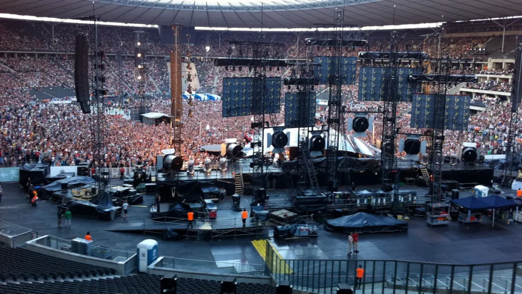 Konzert im Stadion, Blick von hinten über die Bühne auf das Publikum.